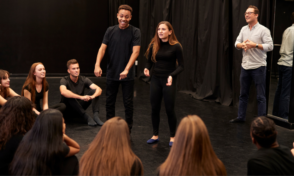Drama students rehearse with their teacher in school theatre department